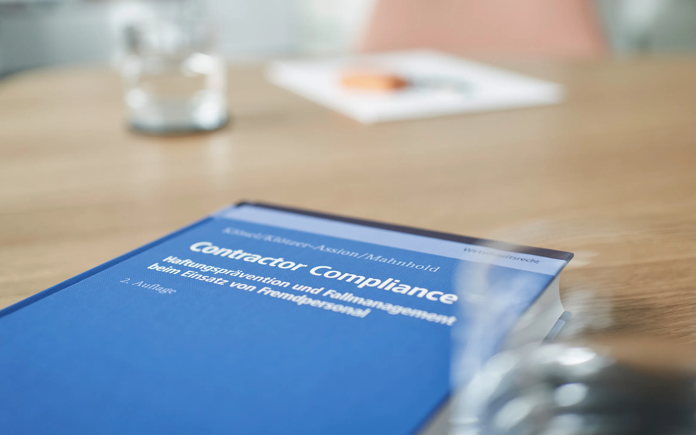 Fachbuch „Contractor Compliance“ auf dem Besprechungstisch