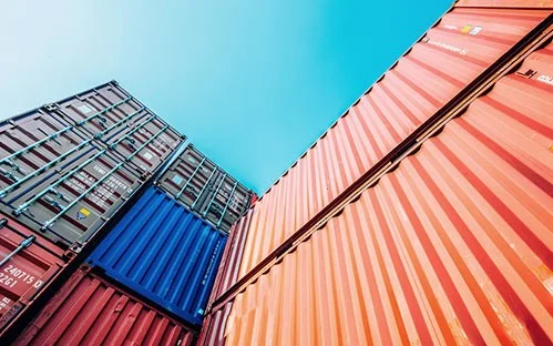 Gestapelte Seecontainer vor blauem Himmel