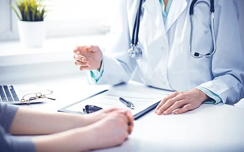 Ärztin und Patientin im Gespräch am Schreibtisch